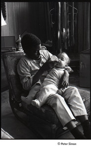 Party at Jackie Robinson's house: David Robinson feeding a baby with a  bottle - Digital Commonwealth