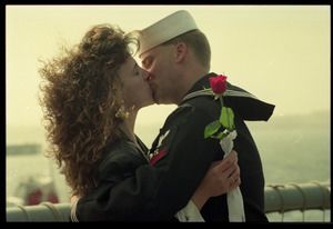 Woman with a rose kissing a sailor from the USS Roberts returning from Persian Gulf War duty