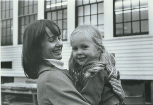 Dr. Alice H. Eagly standing outdoors, holding child