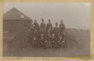 Class of 1887 sitting on a grass mound at their 10 year reunion. Evan F. Richard is in the middle of the front row