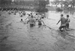 Rope pull participants wade through campus pond