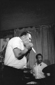 James Cotton at Club 47: James Cotton playing harmonica into a microphone onstage with drummer Francis Clay at right