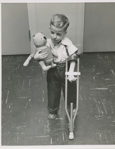 Young boy with stuffed animal and crutch