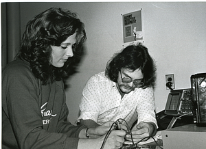 Unidentified woman and man working with electronics