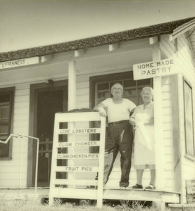 My grandparents standing on the porch of their bakery and fish market