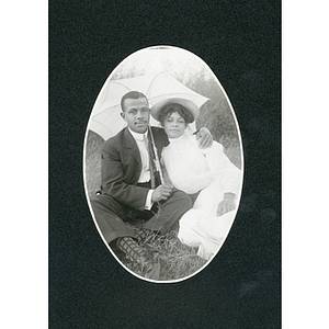 Couples photograph, young man and young woman pose under umbrella