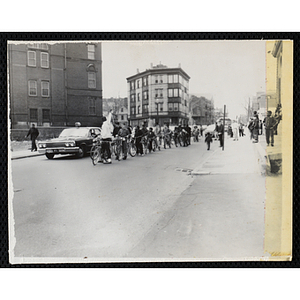 Boys take a group bicycle ride on a city street with a Boston Police escort