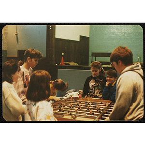 A group of children play foosball