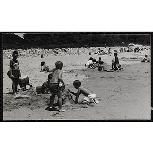 Children sculpt sand on a beach
