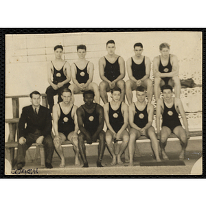 A swim team poses for a group shot with their coach