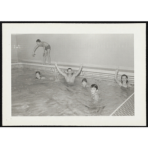 Children pose for a shot as they swim in a natatorium pool