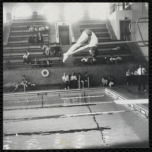 A boy performs a dive during a Boys' Club swimming championship