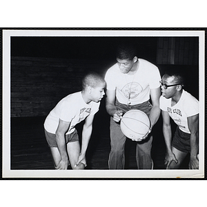 Professional basketball player James "Jimmy" Walker offers instruction to two Roxbury Clubhouse members