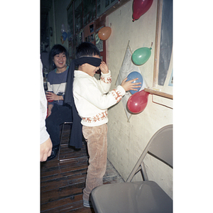 Children play "pin the tail on the donkey" with balloons, at a Chinese Progressive Association celebration