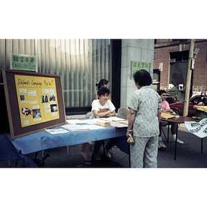 People talking at a voter registration table