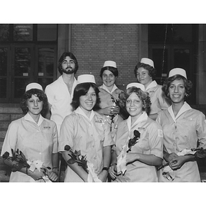 College of Nursing graduates holding roses