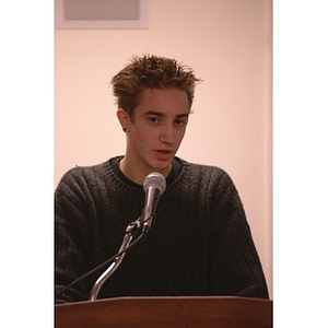 A male student senator speaking to the Student Government Association during a meeting