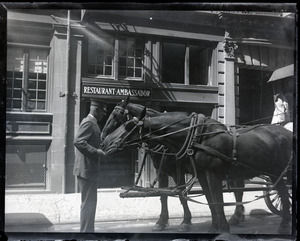 Special Officer Jack Flavin feeding horses pulling a buggy in front of the Restaurant Ambassador