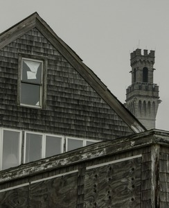 Pilgrim Monument rising behind the shake siding of a building, Provincetown