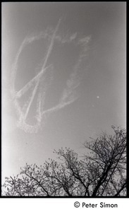 View of a skywriting peace symbol dissolving in the wind