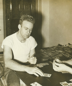 George Sinnicks playing cards in a dorm room