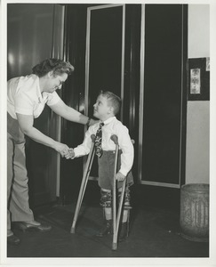 Boy standing with leg braces and crutches