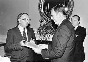 Mayor Raymond L. Flynn receiving book from unidentified man