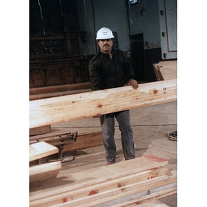 Construction worker holding a plank of wood during the renovation work that transformed the All Saints Lutheran Church into the Jorge Hernandez Cultural Center.