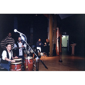 Alex Alvear and other Areyto musicians on a school stage.