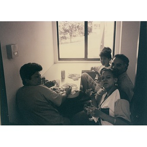 Four Inquilinos Boricuas en Acción staff members having their lunch in a nook with a window.