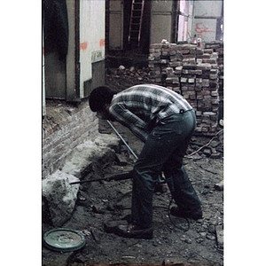 Construction worker drilling into masonry as part of the rehabilitation of a former church into a cultural center.