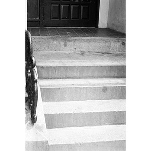 Front steps to a Villa Victoria house with a decorative metal banister.