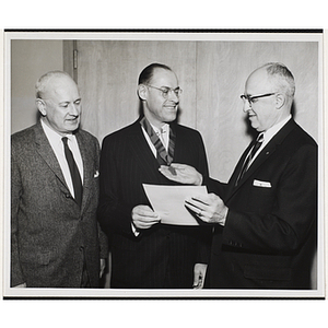 William H. Montgomery, at right, presents an award to Dwight P. Robinson, Jr., while Arthur T. Burger looks on, at the Boys' Club Annual Recognition Dinner at the Boston Museum of Science