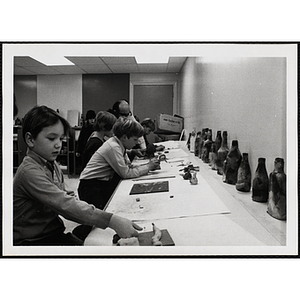 Several children and a staff member in a clay class