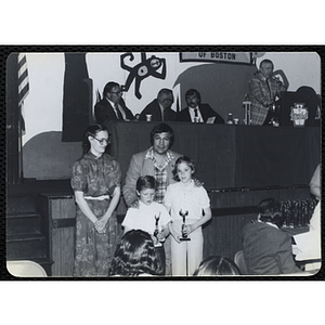 A man and a woman standing with a boy and a girl holding their trophies during a Boys' Clubs of Boston Awards Night