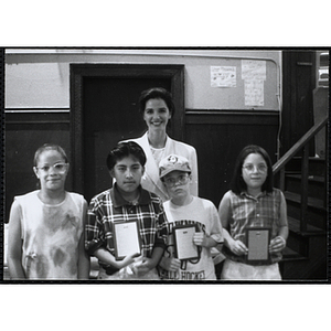 Heather Khan, a former news anchor, posing with four boys and girls holding their awards at a Kiwanis Awards Night