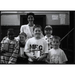 Heather Khan, a former news anchor, posing with four boys and girls holding their awards at a Kiwanis Awards Night