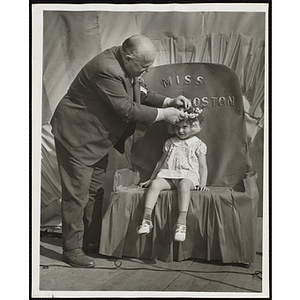 J. Willard Hayden places a flower crown on Miss South Boston, the winner of the Boys' Club Little Sister Contest