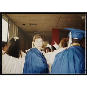 A teenage boy poses for a shot during an Edwards School graduation ceremony