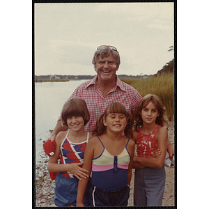 Executive Vice President Frederick J. Davis poses with three girls outdoors
