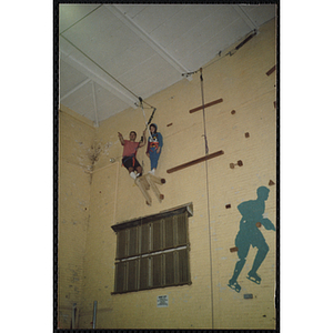 A girl and an indoor climbing supervisor stand on a platform