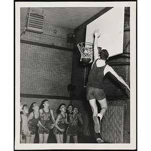 A man dunks the ball for a group of boys