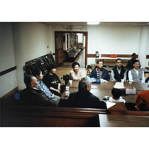 Chinese Progressive Association members sit together at a table during a meeting