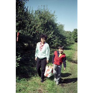 People carrying apples during a Chinese Progressive Association trip