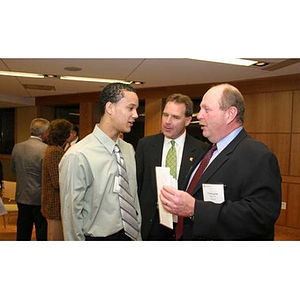 Odalis David Polanco speaks with two men at the Torch Scholars dinner