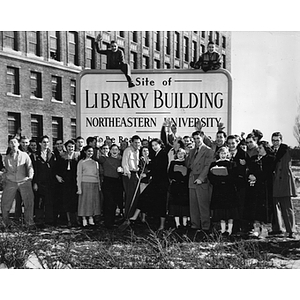 "Site of Library Building" sign surrounded by students