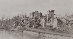 Badly damaged buildings along a river bank, Varennes-en-Argonne