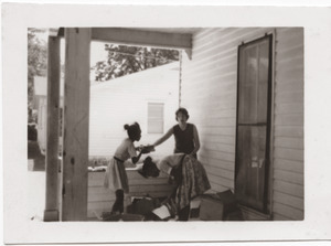 Marjorie Merrill and young girls packing books on the porch of Rust Avenue house rented by the Congress of Federated Organizations (COFO)