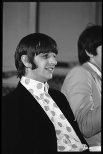 Ringo Starr seated at a table during a Beatles press conference