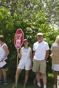 Woman with a stop sign-shaped sign reading 'Stop ICE' at a pro-immigration rally in front of the Chatham town offices building : taken at the 'Families Belong Together' protest against the Trump administration's immigration policies